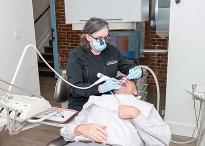 dental hygienist performing a cleaning on a patient at Applegate Dentistry & MedSpa