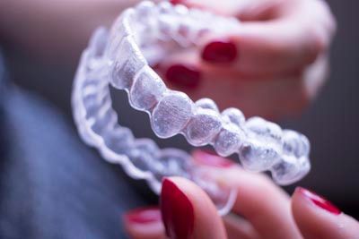 woman holding her suresmile aligners